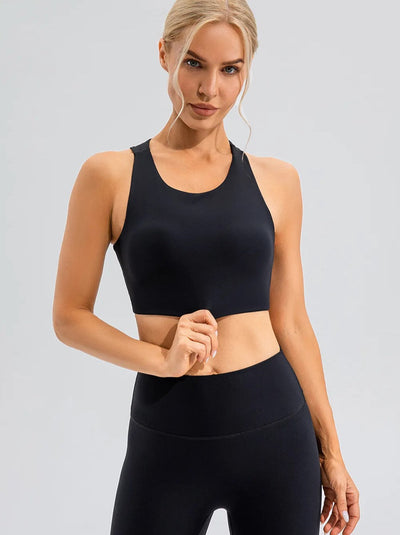 Woman wearing black sportswear set with high-waisted leggings and a racerback sports bra.