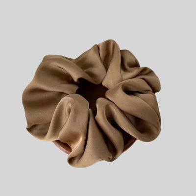 Beige satin hair scrunchie with gathered, ruched loops.