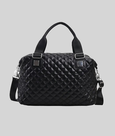 Black quilted handbag with top handles and a detachable shoulder strap.