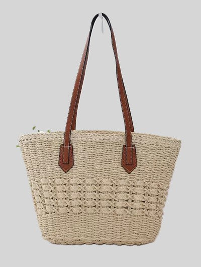 Woven straw tote bag with brown leather handles, spacious everyday carryall.