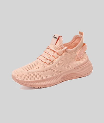 Pastel pink athletic shoe with knit mesh upper, lace-up front, and chunky sole.