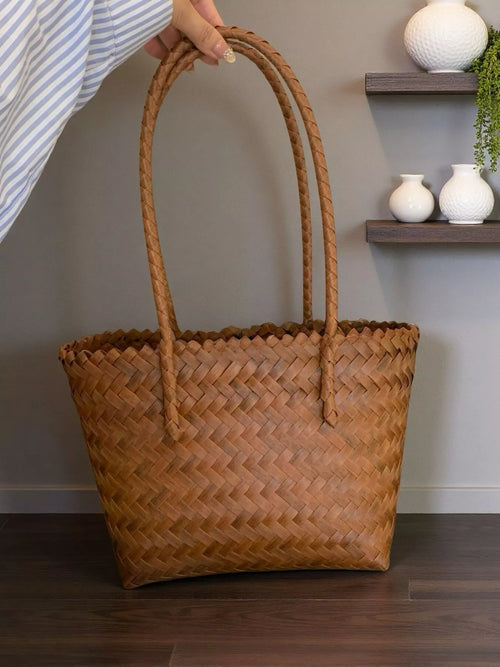 Brown woven tote bag with braided sides and two tall handles