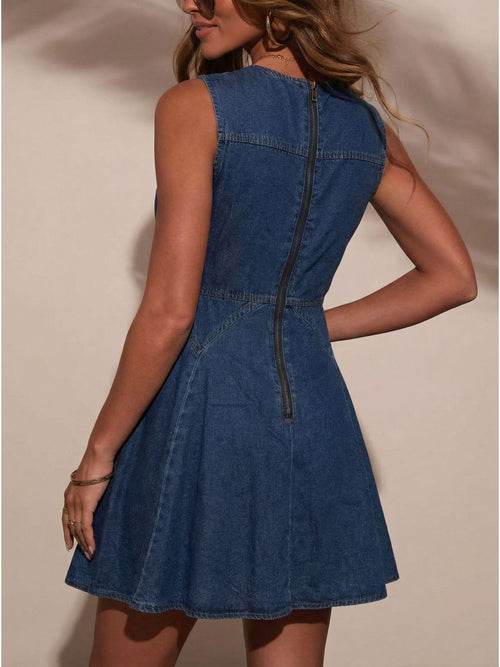Back view of sleeveless dark denim dress with fitted waist and pleated skirt