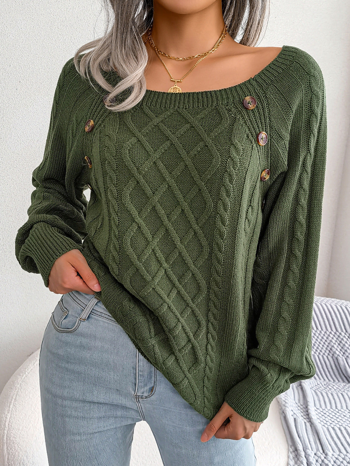 Green cable-knit sweater with diamond lattice knit and small button accents