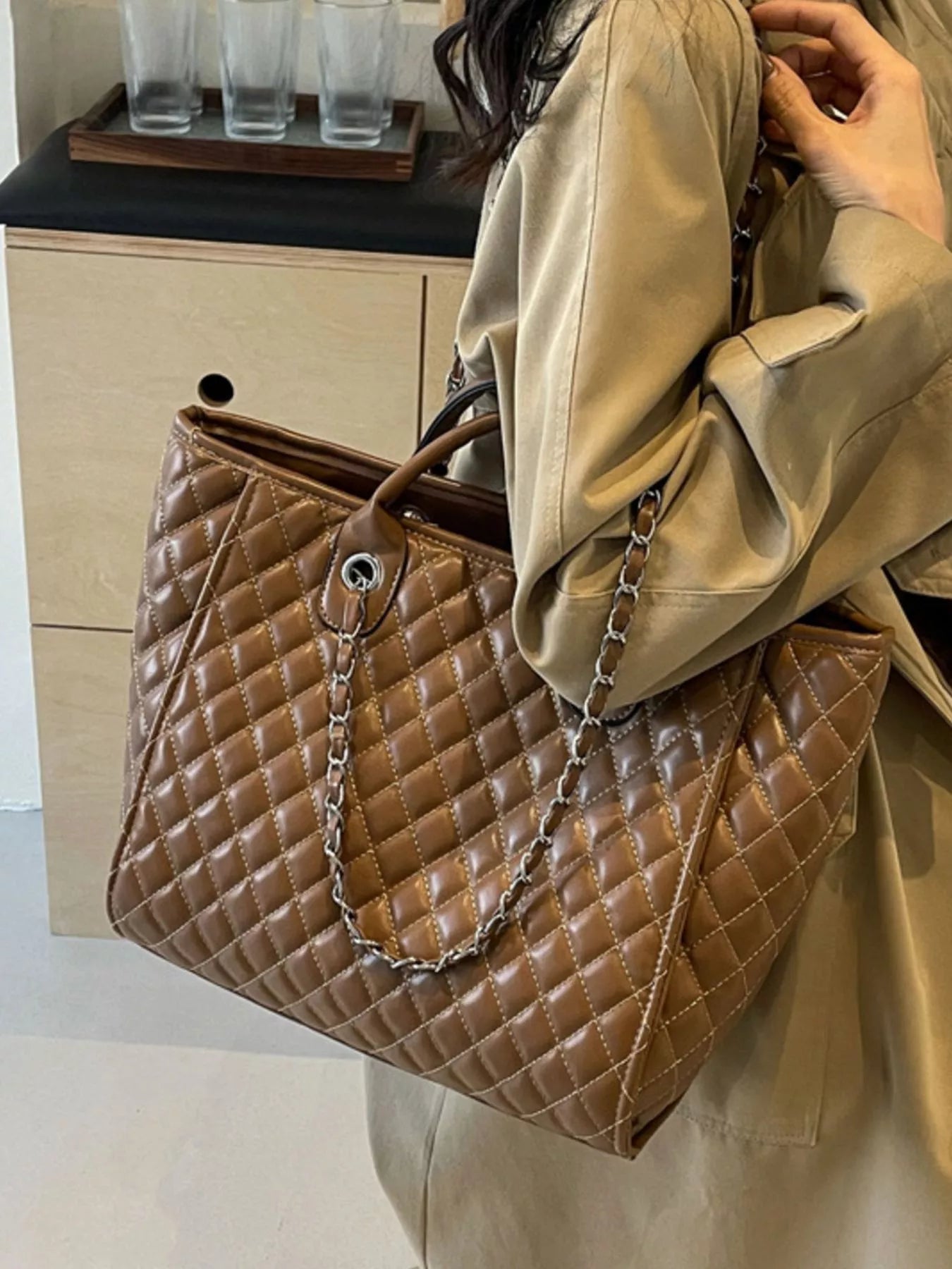 Brown quilted medium vegan leather tote with chain strap and front ring clasp detail