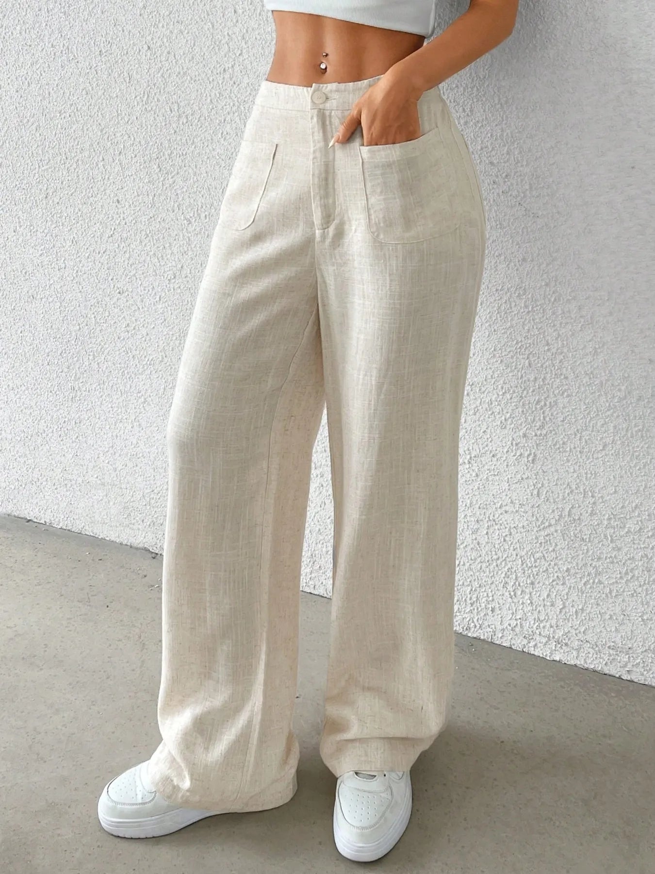 Beige wide-leg pants with front closure, side pockets, and relaxed wide legs.