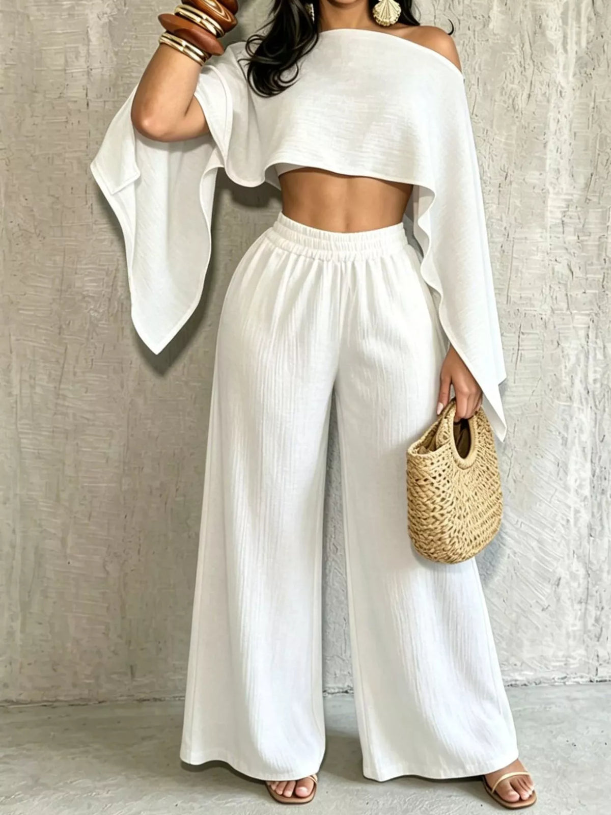 White boat-neck crop top and wide-leg pants set with draped sleeves and elastic waistband