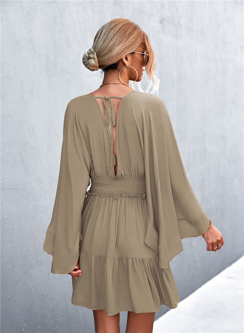 Taupe surplice dress back view with smocked waist and keyhole tie
