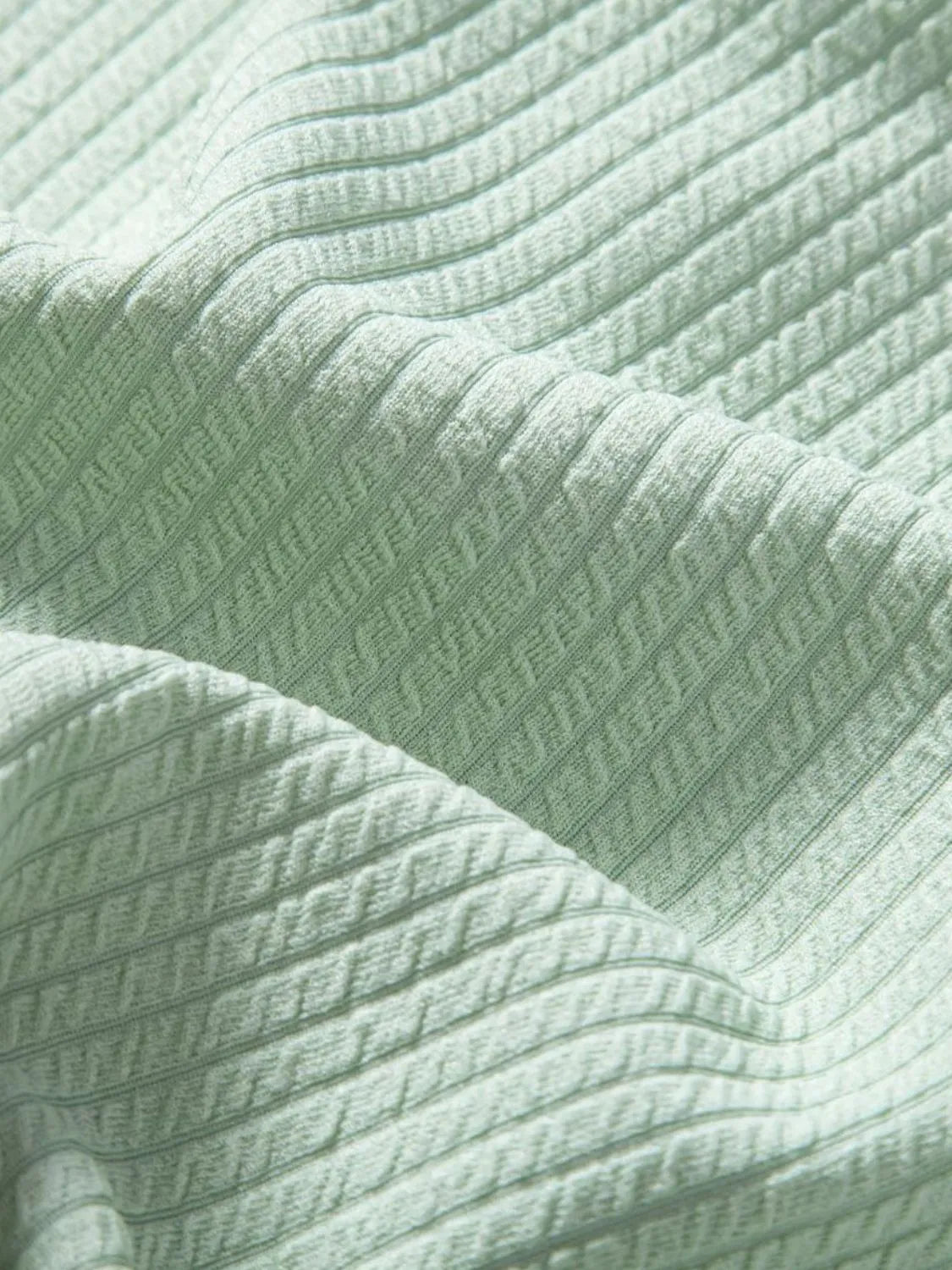 Mint green ribbed fabric close-up with subtle striped texture