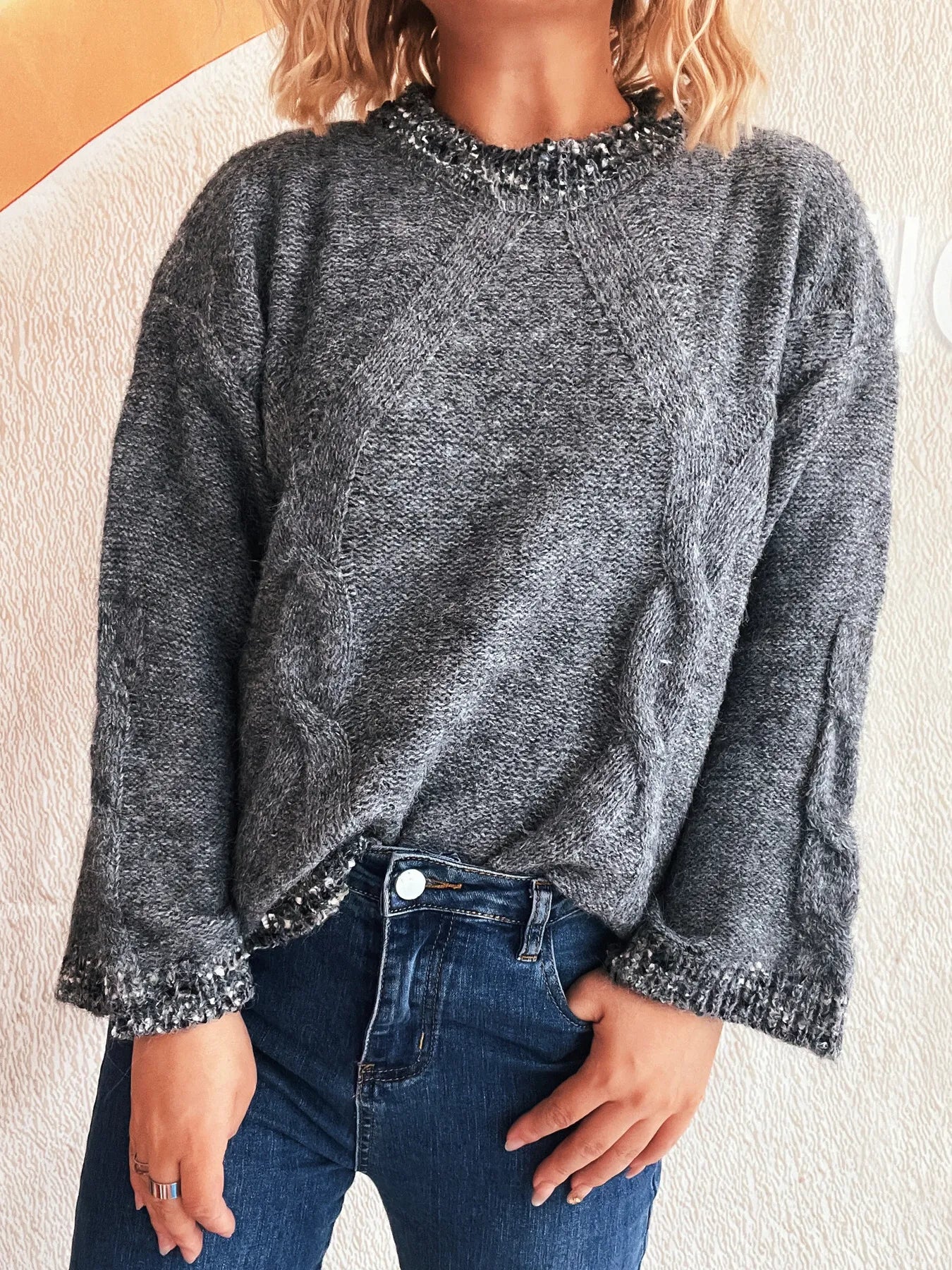 Dark gray round-neck sweater with contrast trim at neckline, cuffs, and hem.