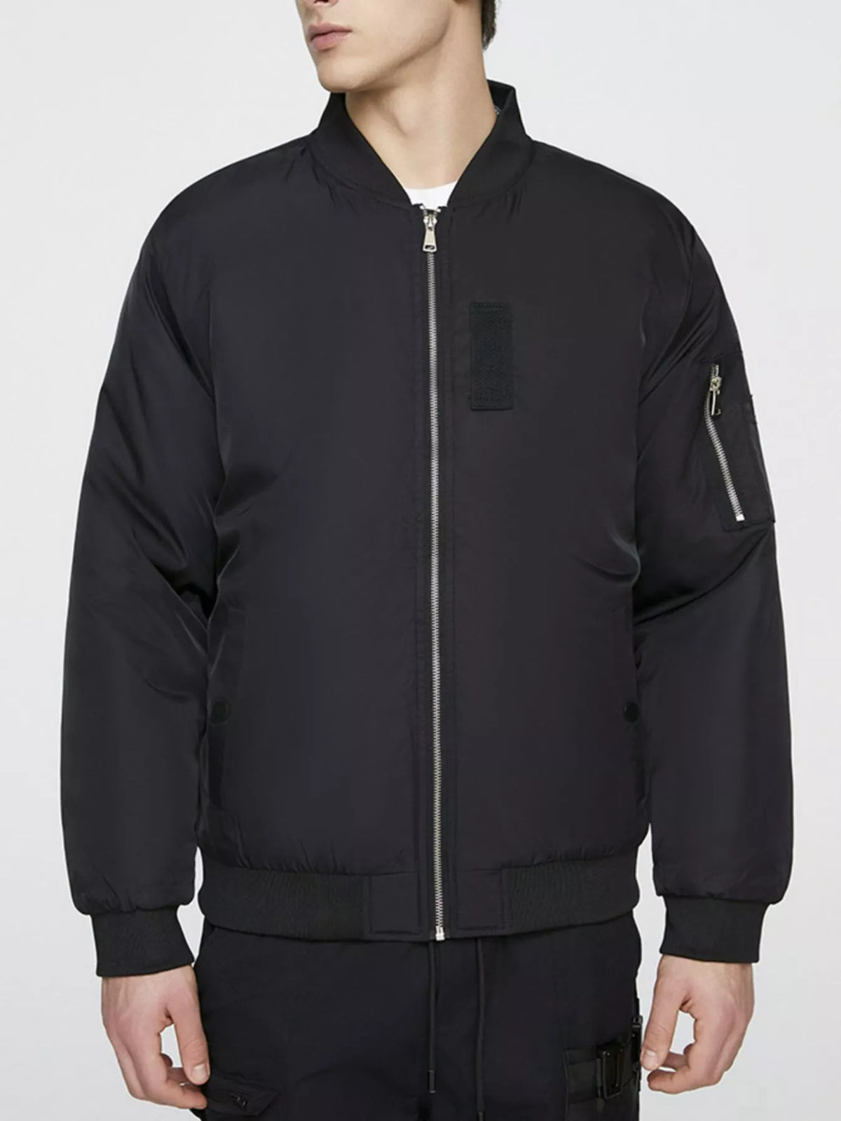 Lightweight black bomber jacket with zip front and right sleeve zipper pocket