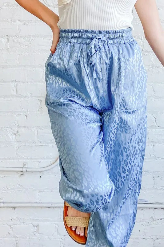 Pale blue satin leopard print joggers with elastic waistband and drawstring bow detail