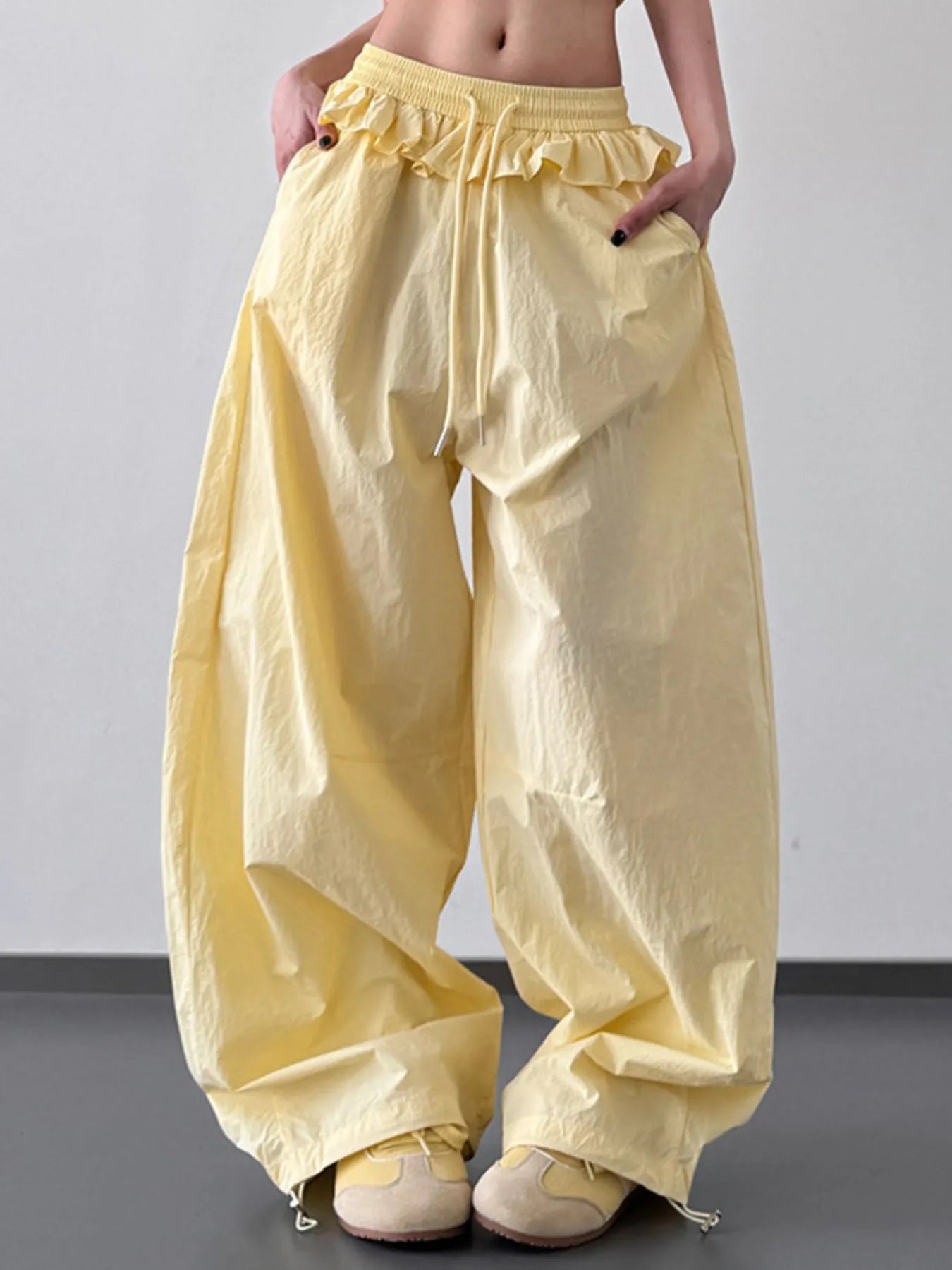 Yellow drawstring wide-leg pants with ruffled waistband and side pocket details