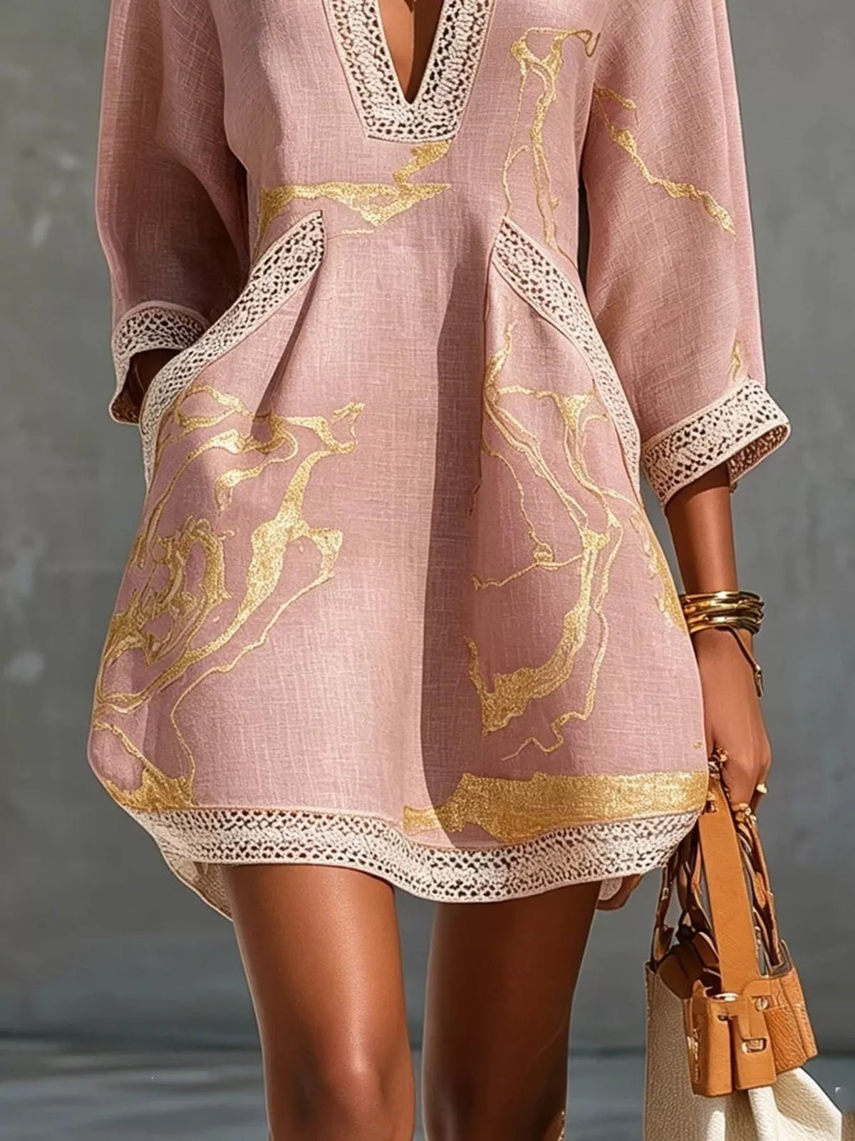Pink mini dress front detail with gold horse print, notched V lace trim, and lace hem