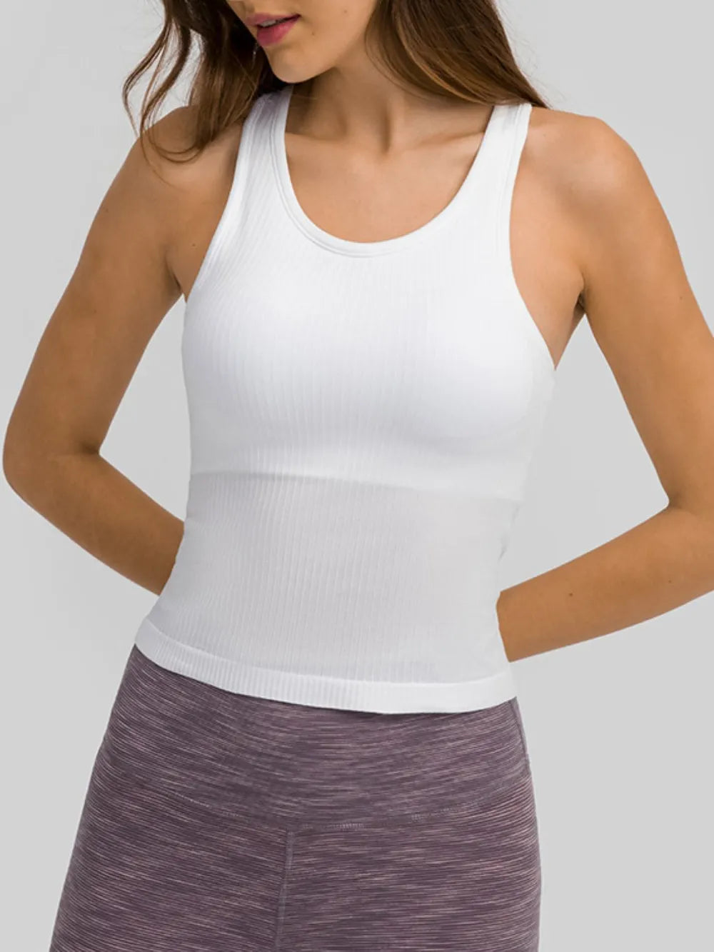 White active tank top with round neck and racerback straps for athletic wear.