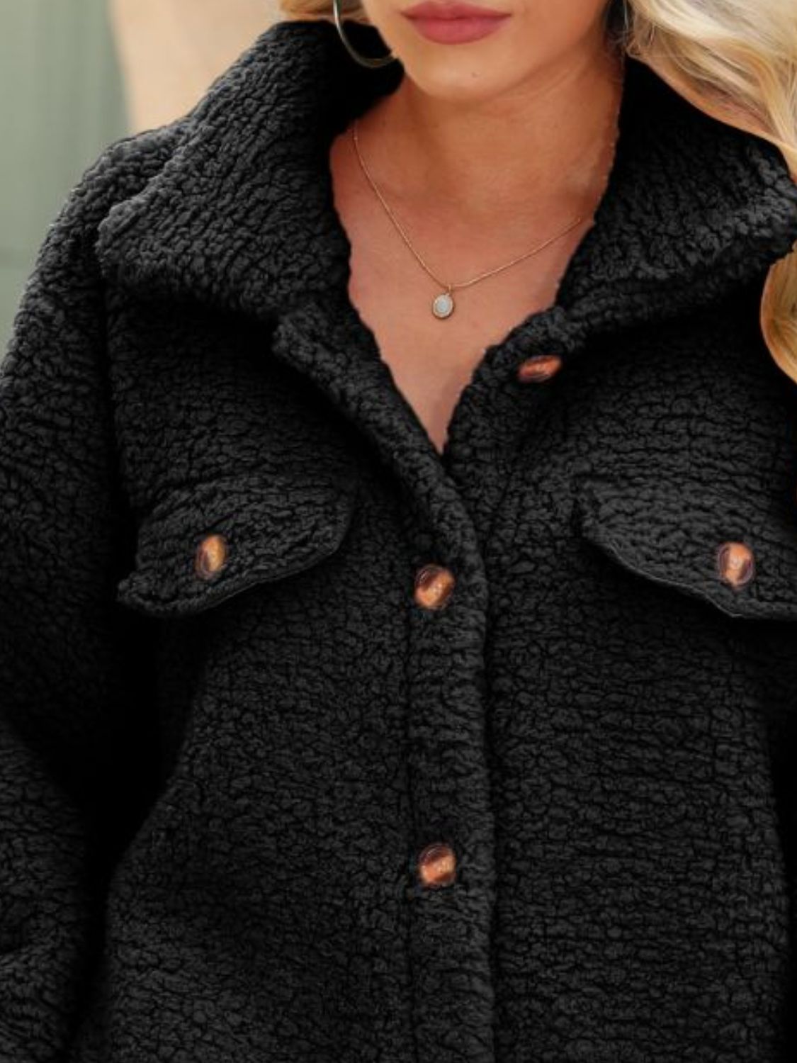 Black sherpa-style collared coat with button placket and chest pocket detail