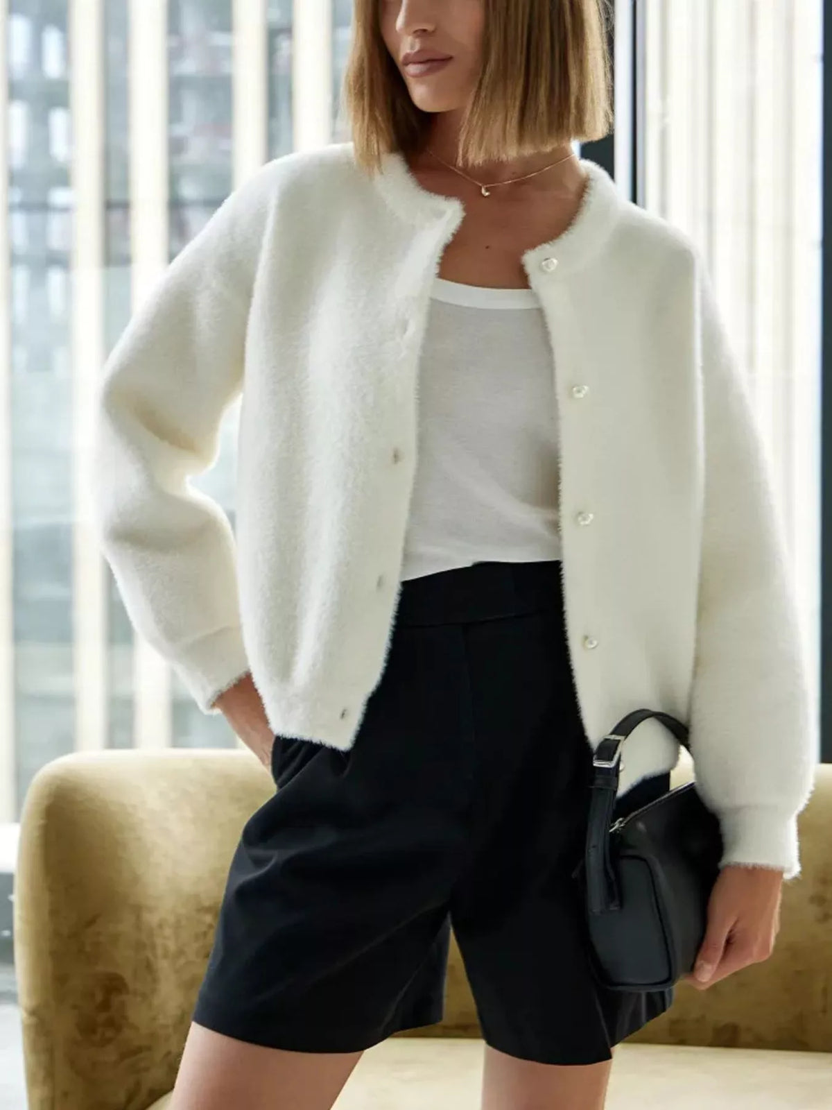 White fuzzy knit button-down cardigan with round pearl buttons and long sleeves