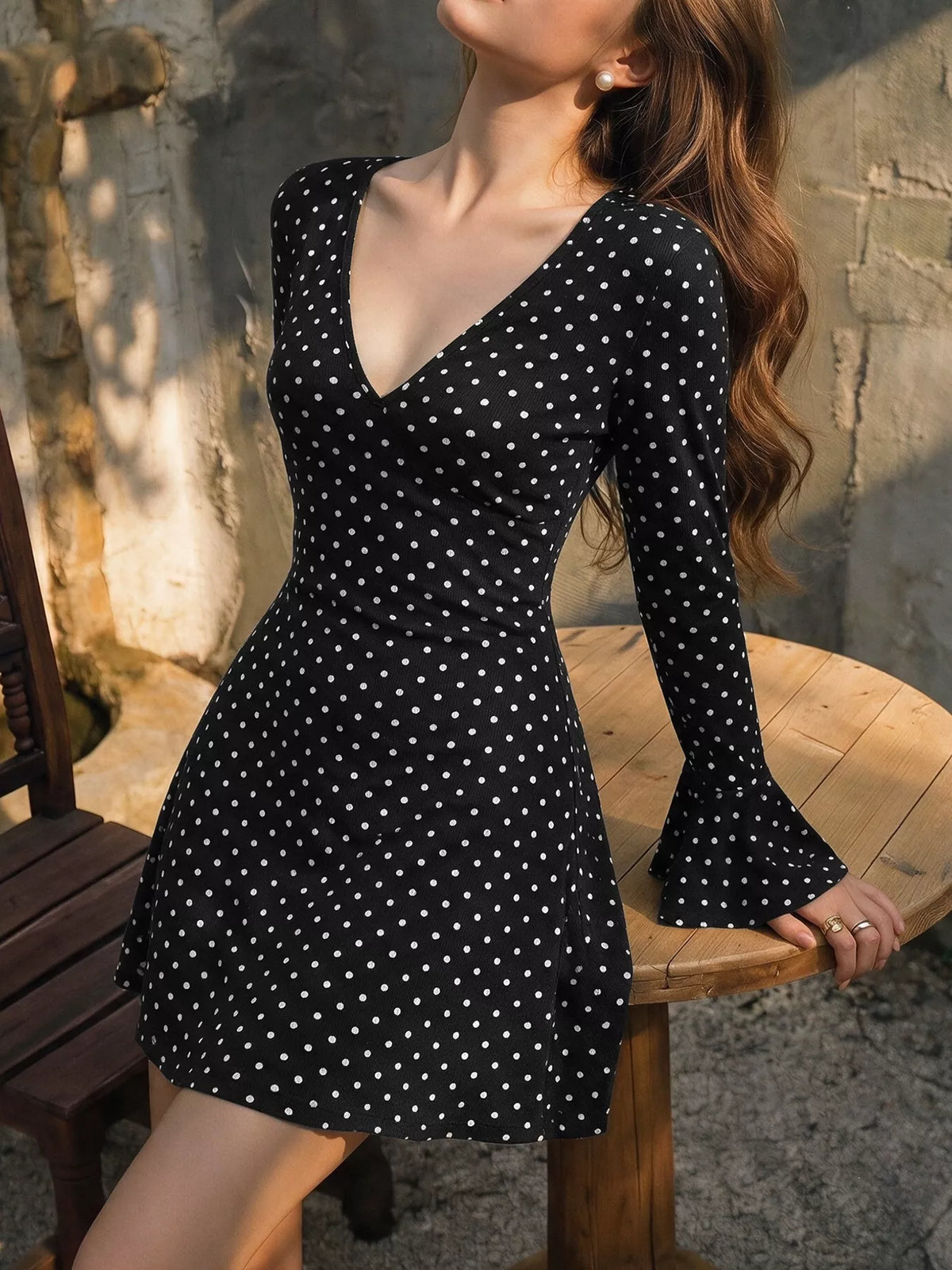 Black polka dot long-sleeve mini dress with V-neck and flared skirt