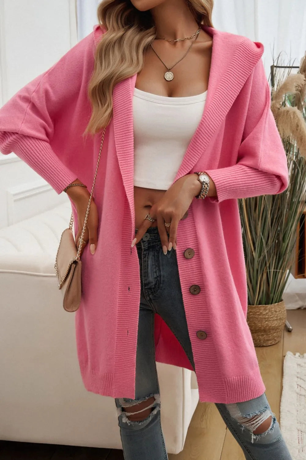 Pink hooded cardigan with long sleeves and front buttons, relaxed drape.
