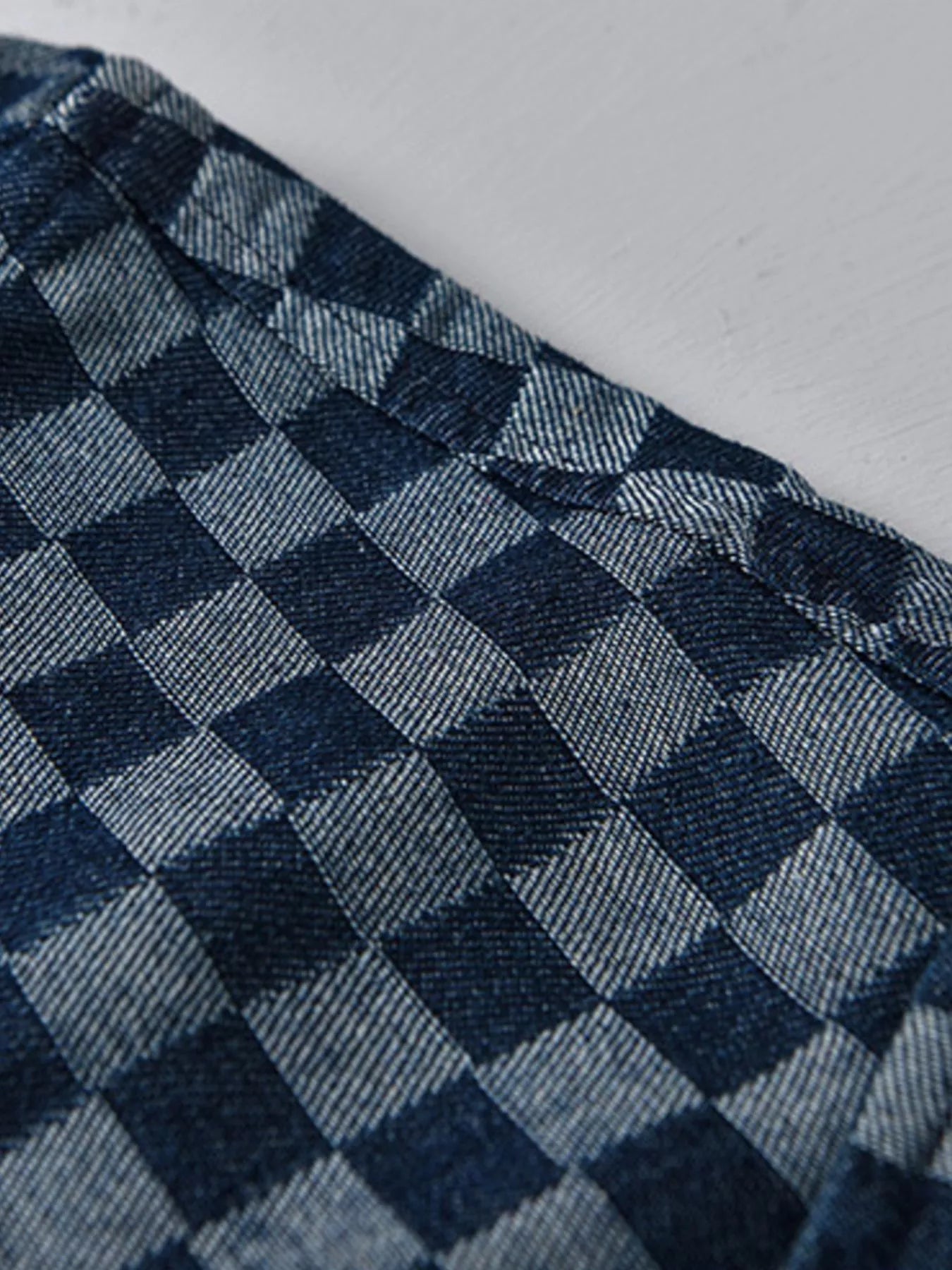 Close-up of blue checkered fabric texture on a short-sleeve shirt