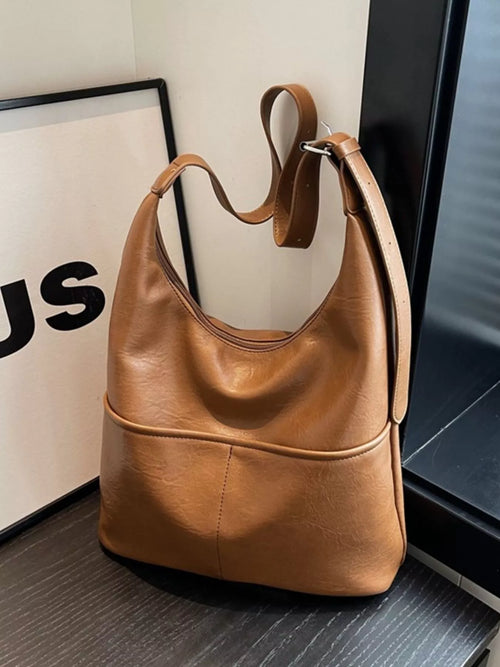 Brown hobo-style shoulder bag with adjustable strap and stitched front panel