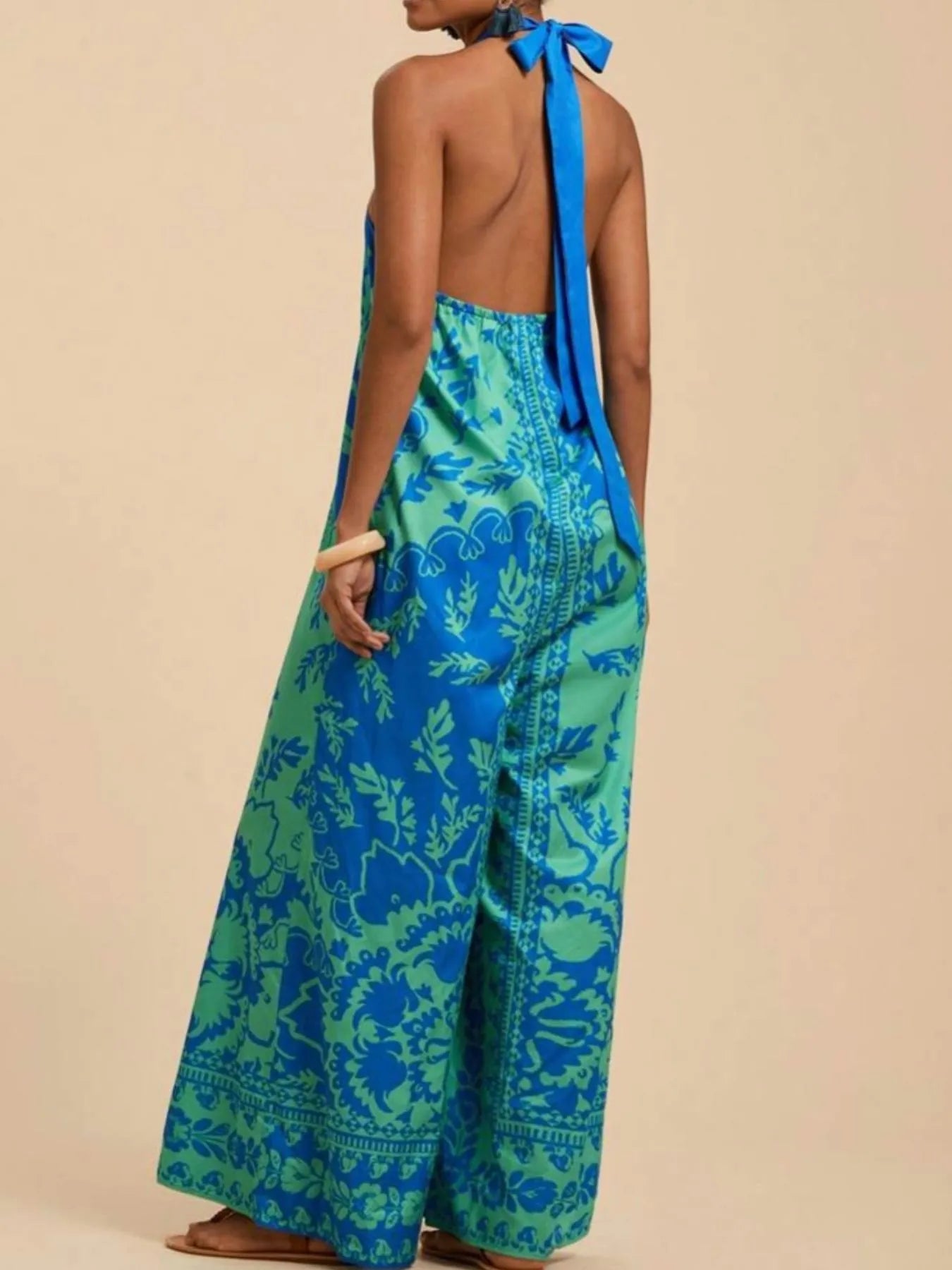 Sky blue halter wide-leg jumpsuit with leafy print and back halter-tie detail