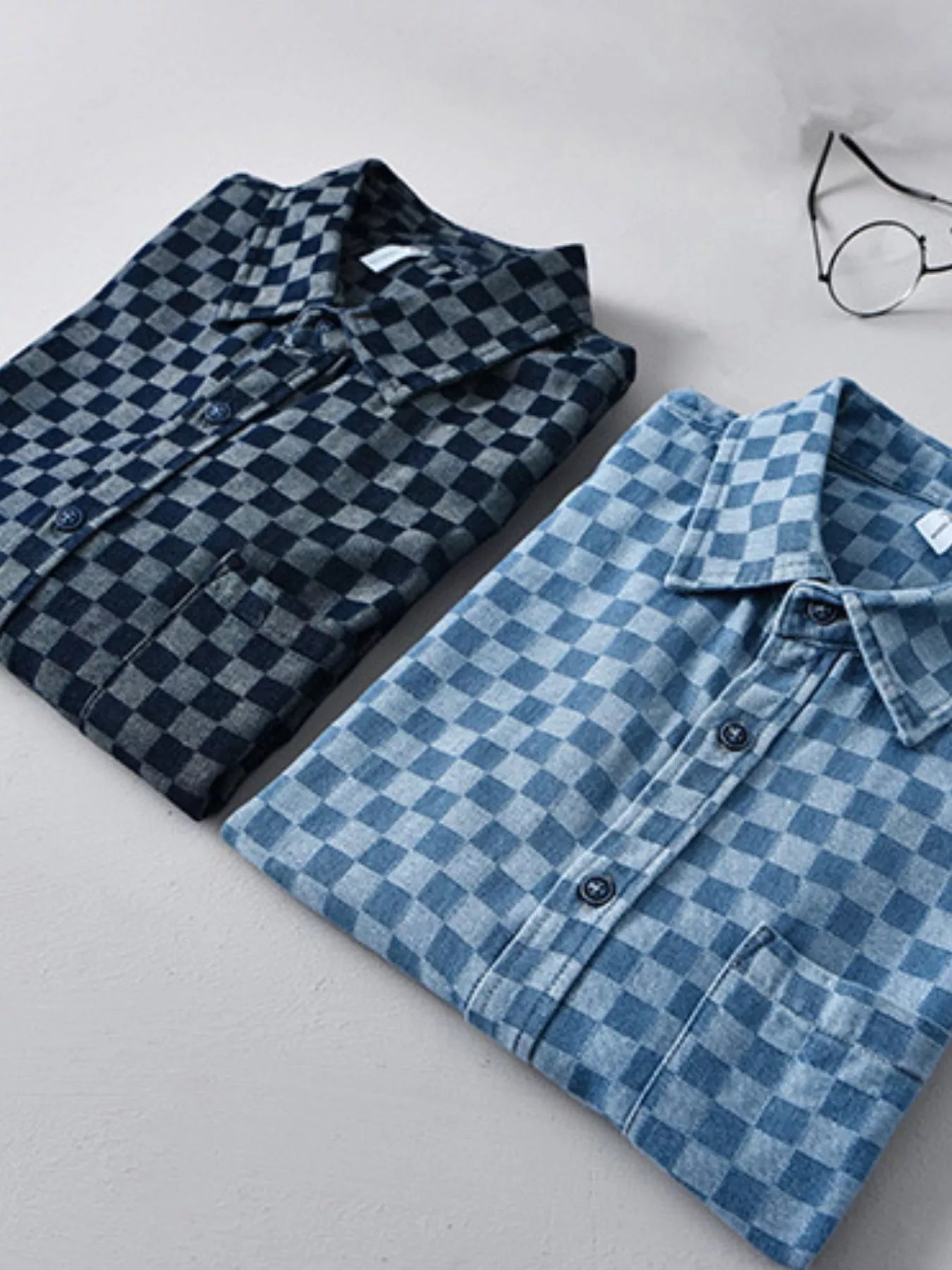 Two checkered short-sleeve casual shirts: dark blue and light blue on a flat lay