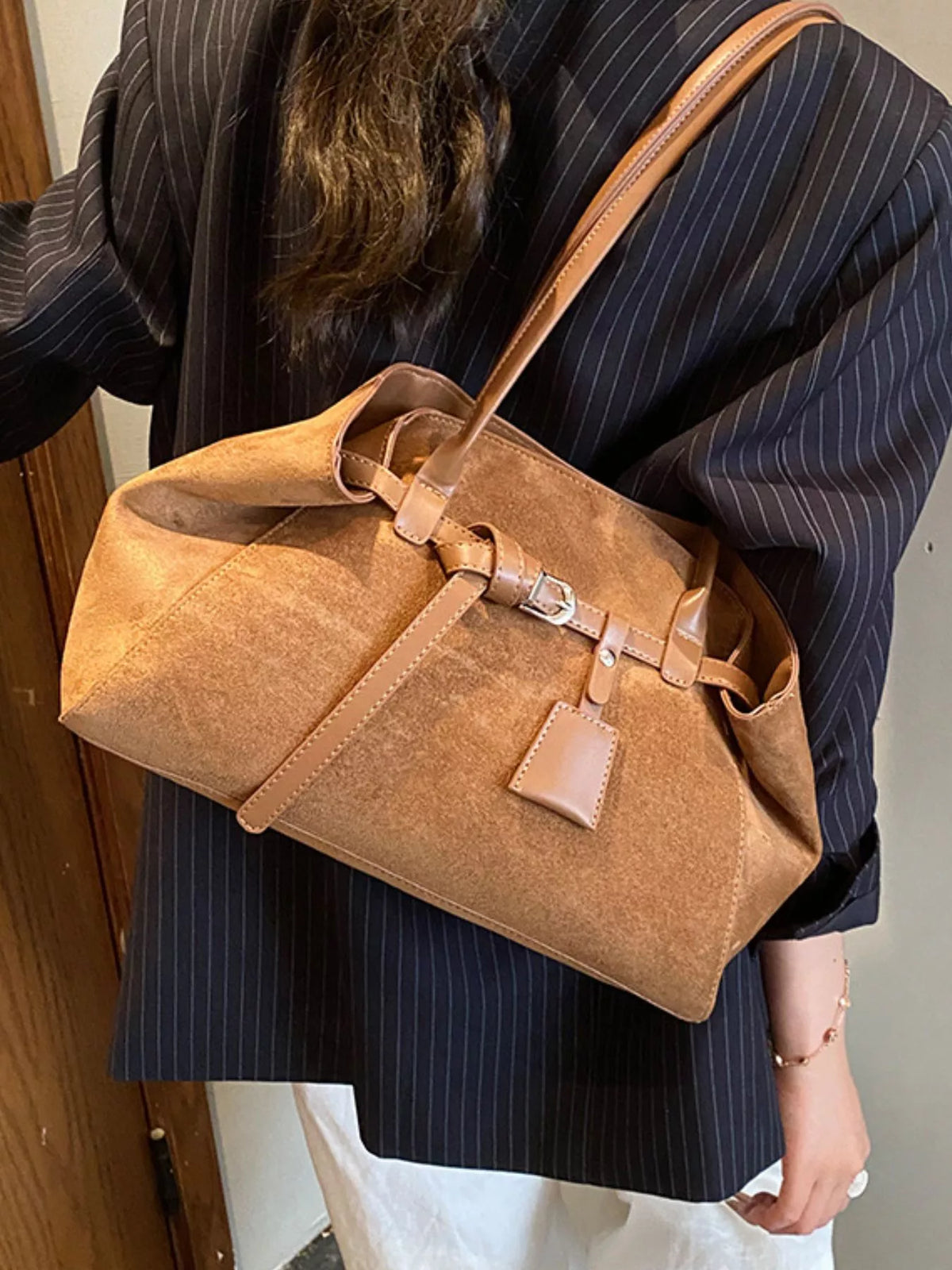 Coffee brown suede buckle shoulder bag with adjustable strap and front tag patch