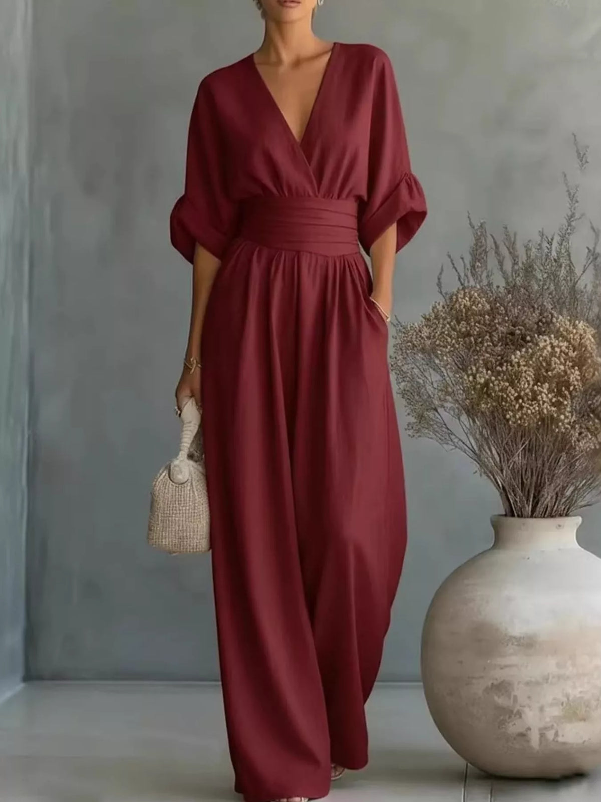 Burgundy V-neck wide-leg jumpsuit with ruched waist and half sleeves.