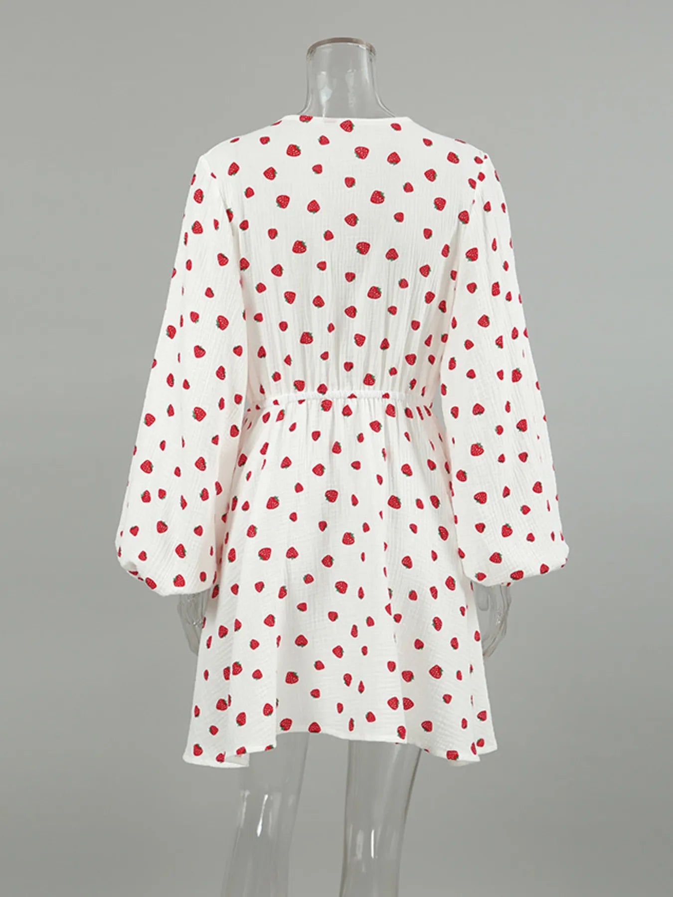 Strawberry print long-sleeve mini dress, white with red berries, back view on mannequin