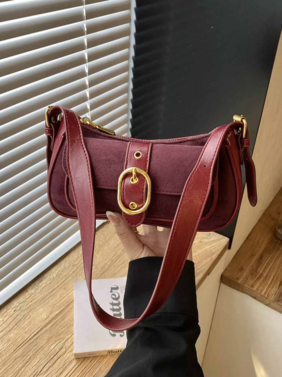 Wine red suede shoulder bag with buckle flap and crossbody strap
