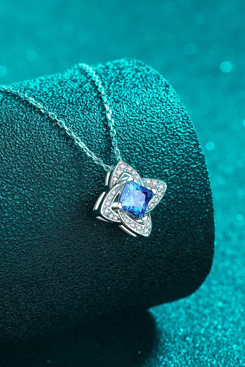 Silver-tone pendant necklace with sky-blue square-cut stone and side accent halos