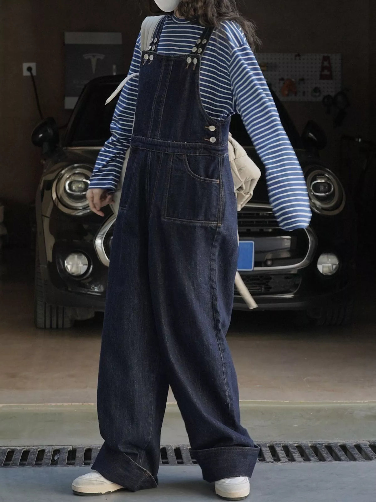 Dark-wash denim overalls, back view with adjustable straps and large rear panel