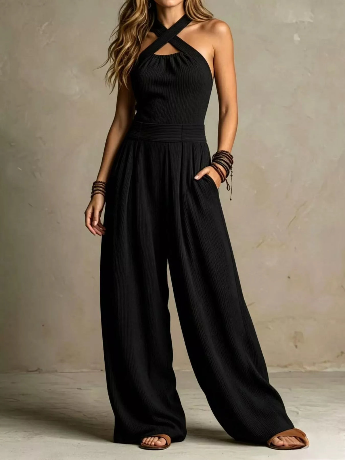 Black halter crisscross wide-leg jumpsuit with gathered waist and flowing wide pants