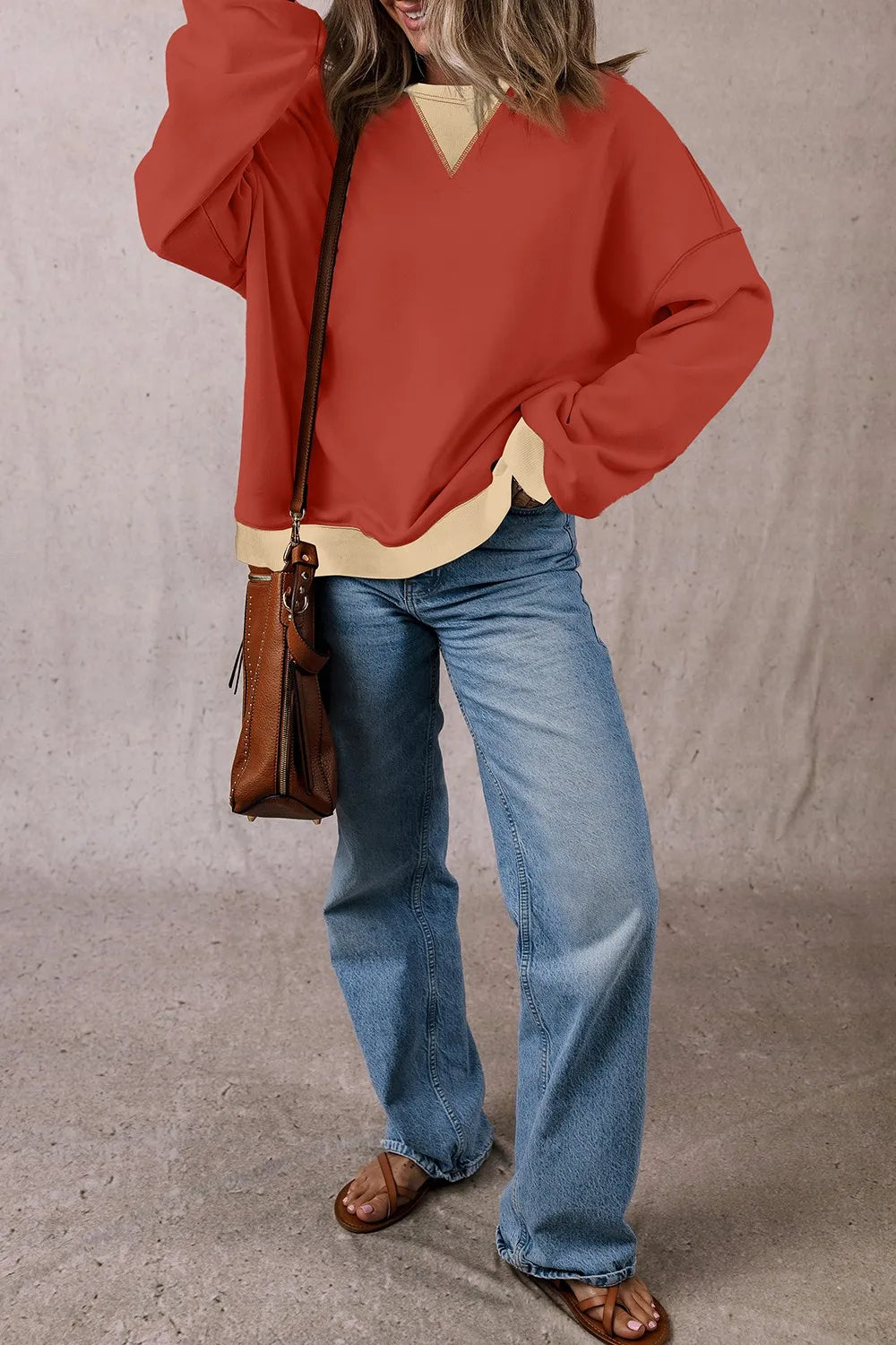 Rust red long-sleeve sweatshirt with light ribbed hem and V-contrast yoke