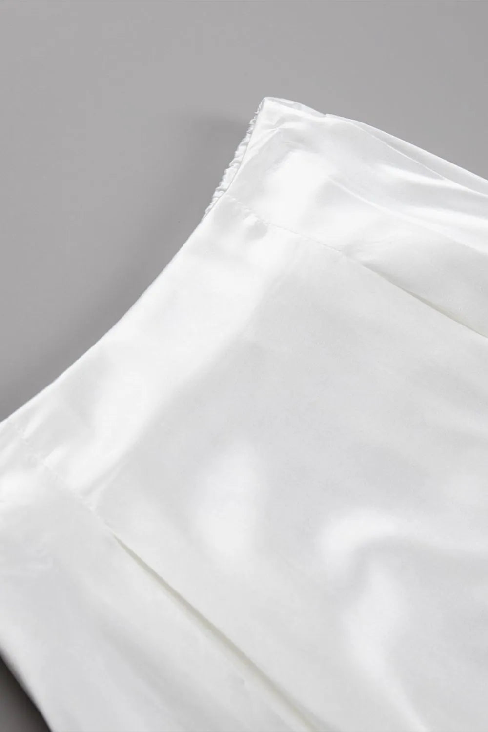 White satin fabric panel with smooth sheen and soft gathered folds