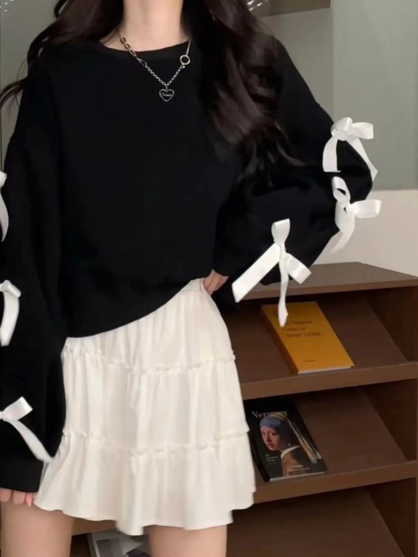 Black round-neck sweatshirt with white bow ties on sleeve cuffs