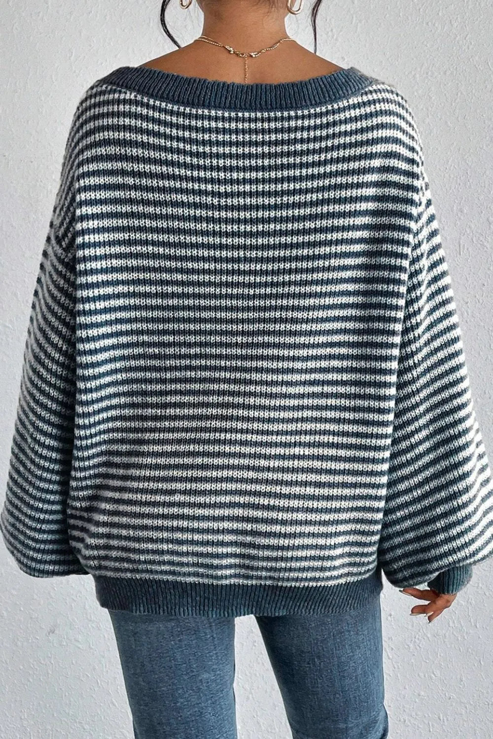 Blue and white striped knit sweater with boat-neck back and ribbed hem