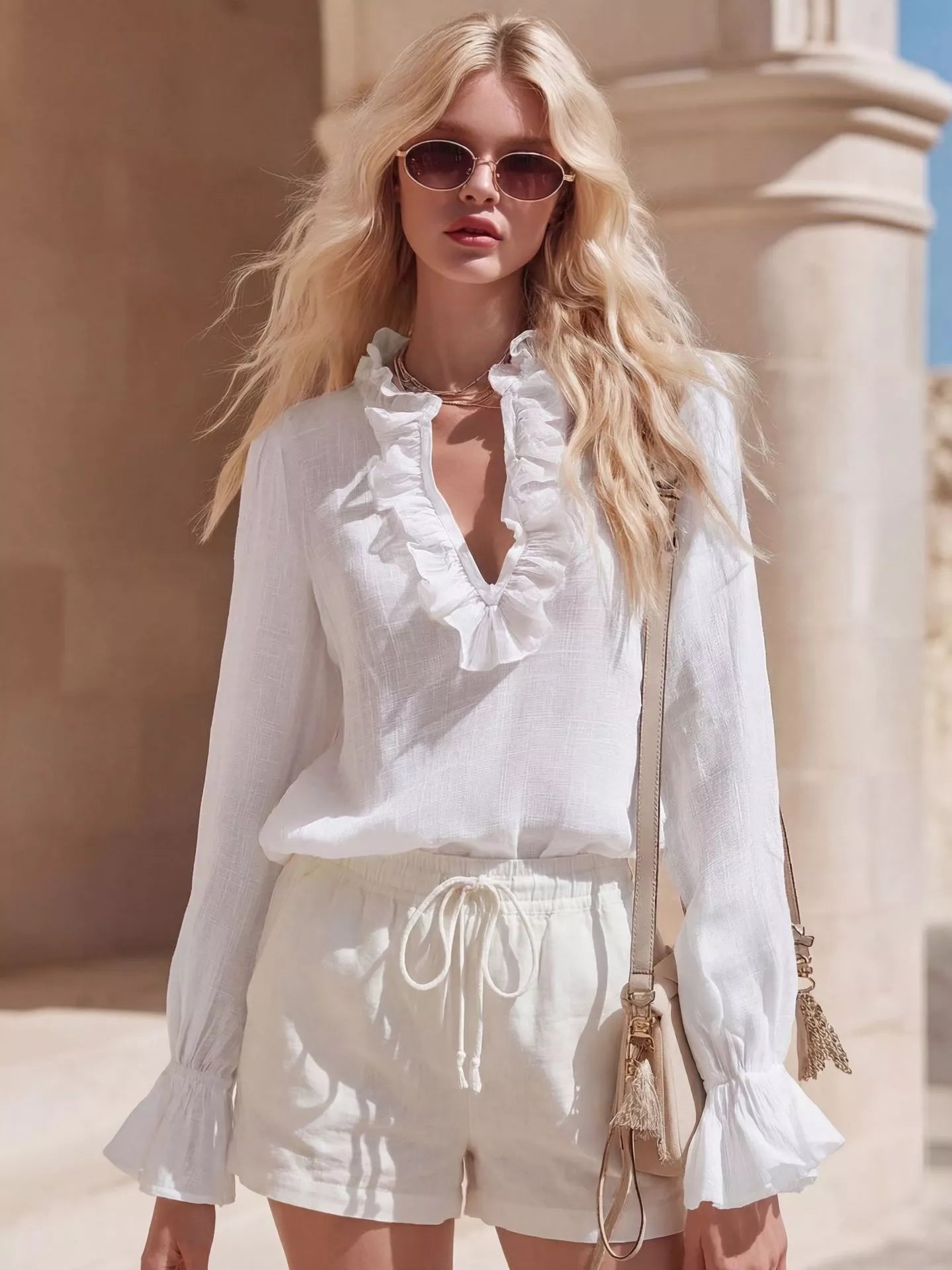 White ruffled V-neck long-sleeve blouse with ruffle trim at neckline and cuffs