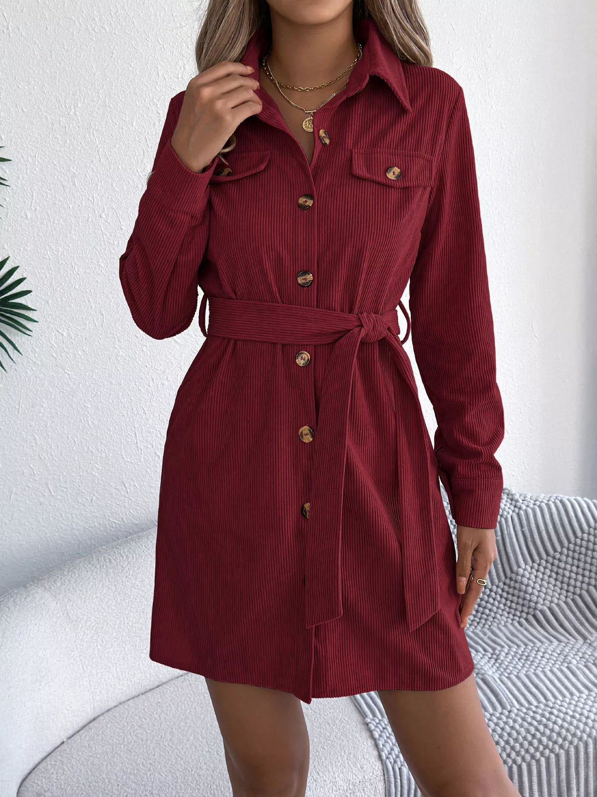 Burgundy corduroy shirt dress with pointed collar, button front, and waist tie belt