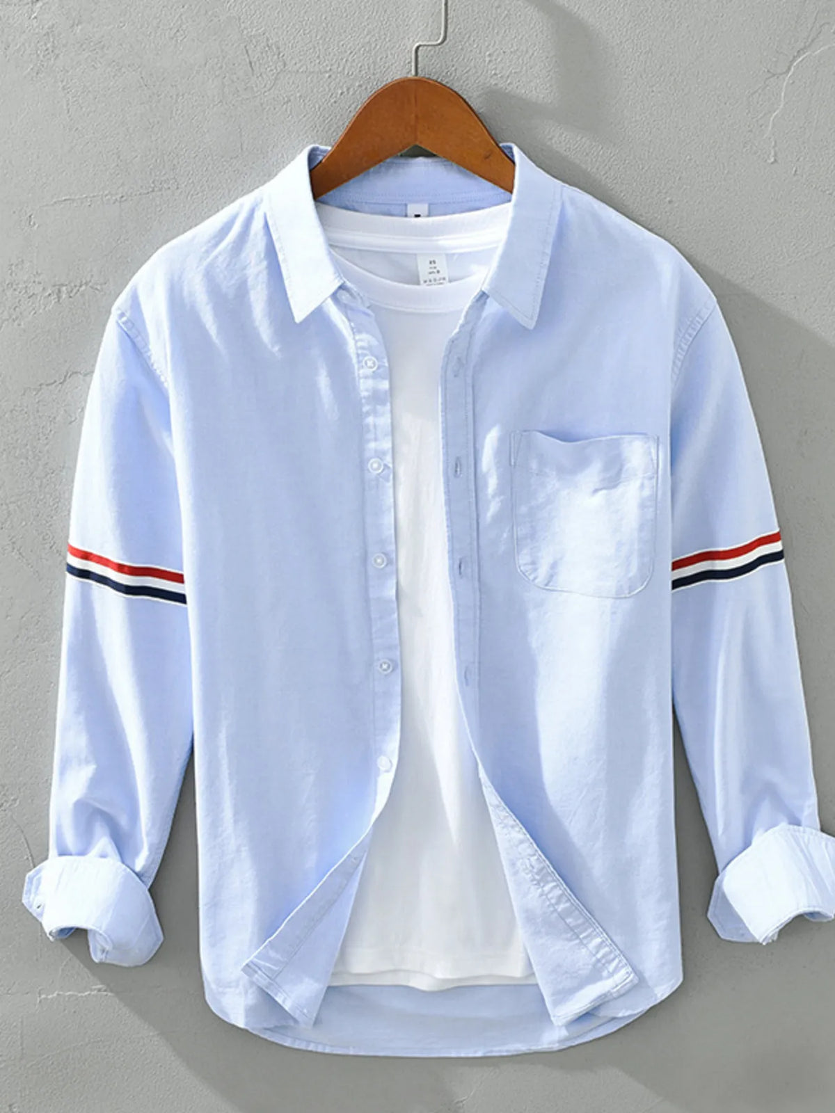 Men's classic long sleeve button-up shirt in light blue, chest pocket and striped cuffs