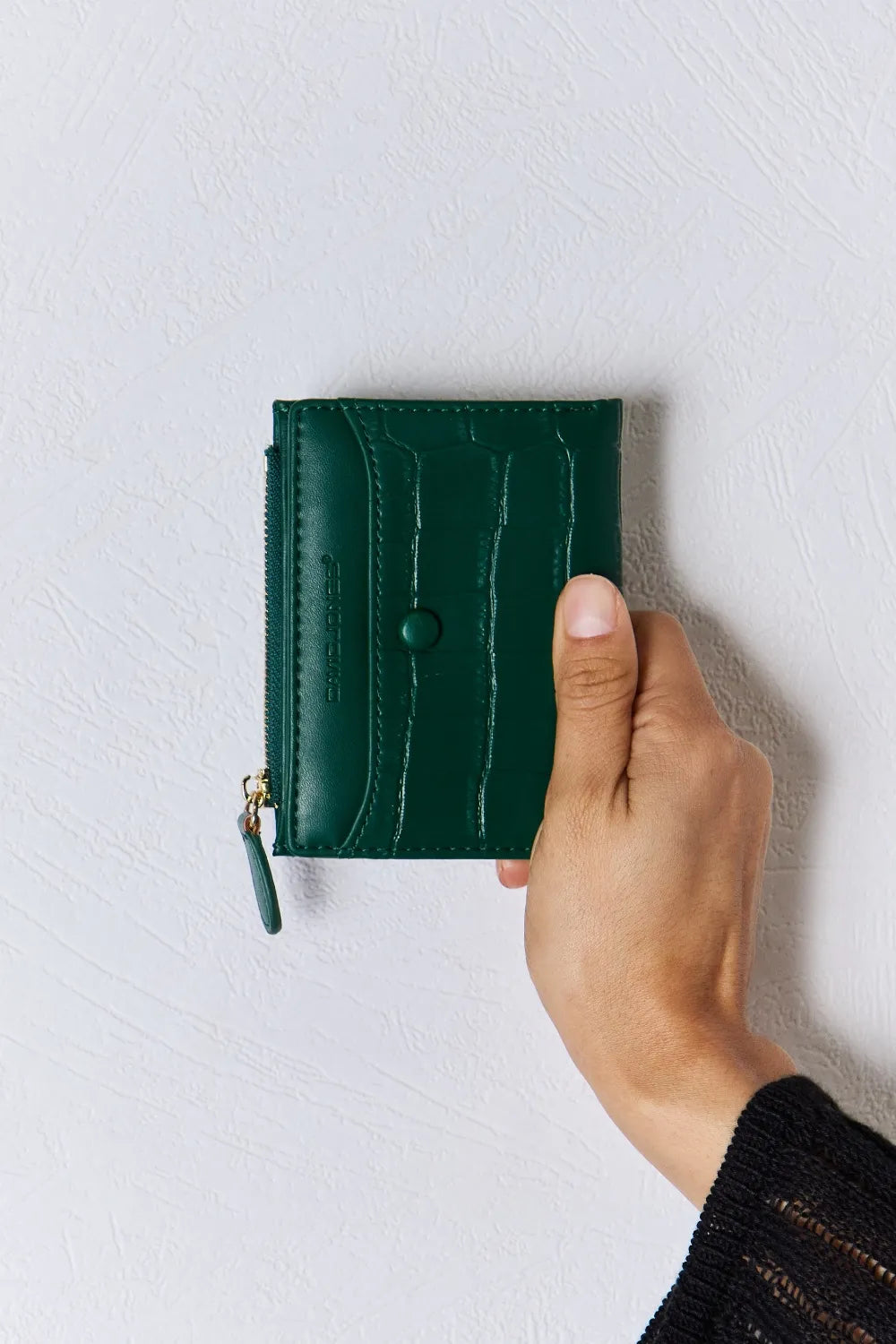 Green textured vegan leather mini wallet with front stitching and zip pull tab