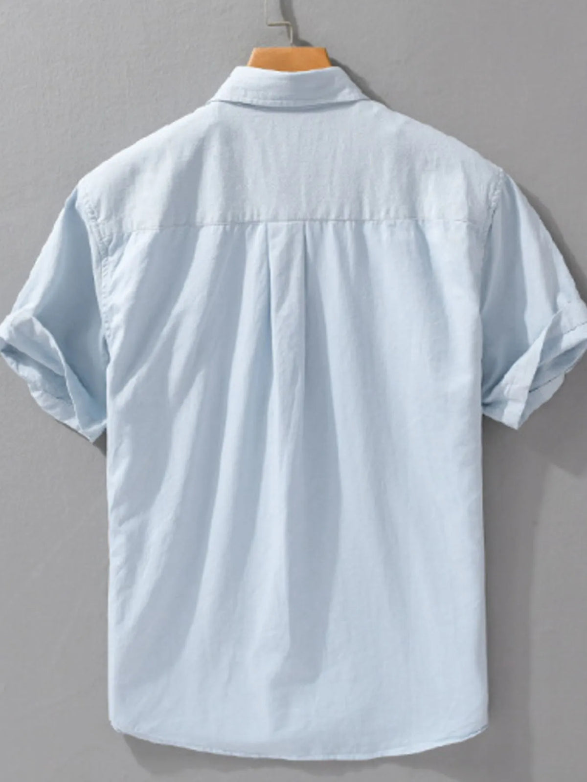Men's short-sleeve cotton button-up shirt, light blue, back view with pleat detailing