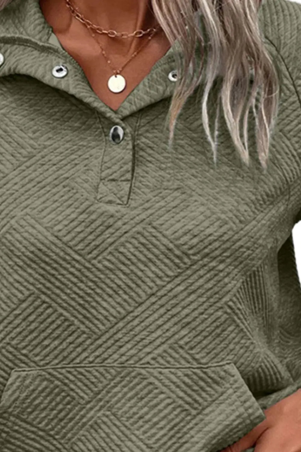 Sage green snap-button sweatshirt chest detail with textured diamond pattern