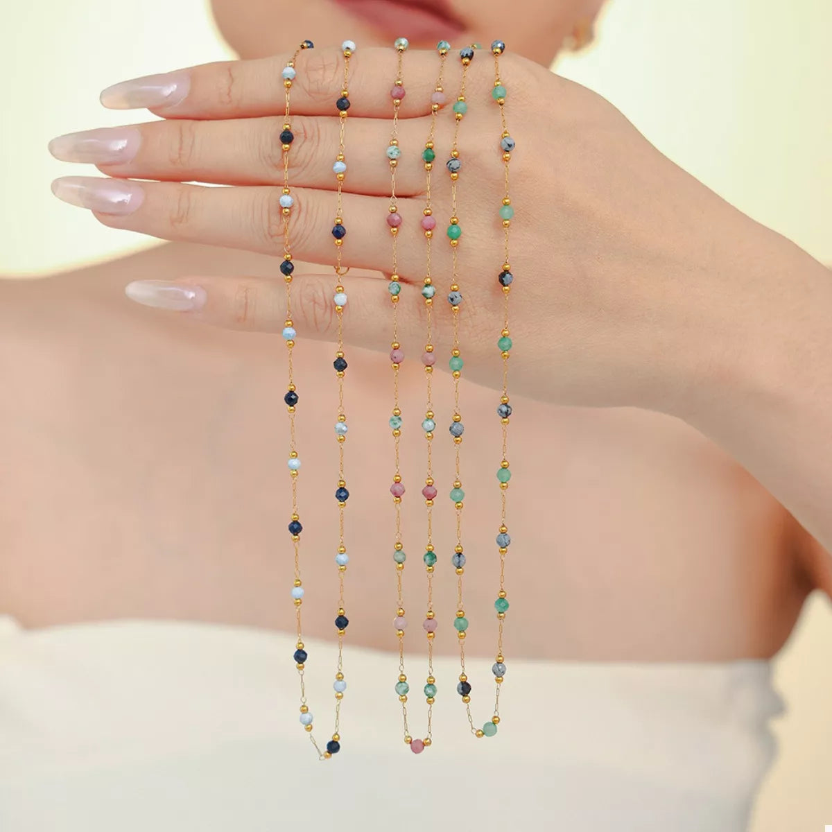 Gold chain necklace with multiple rows of multicolor dangling bead charms