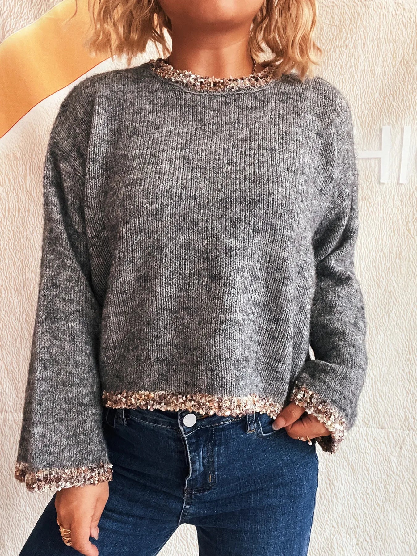 Dark gray cropped round-neck sweater with sparkling rose-gold trim at neck, cuffs, and hem