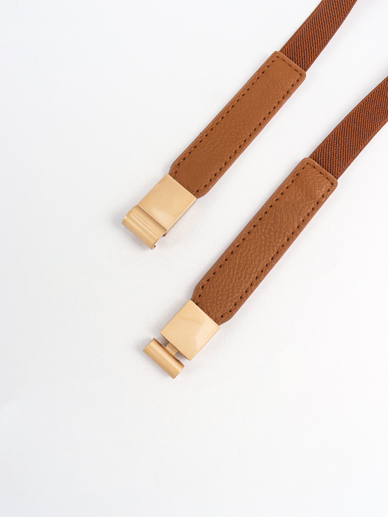 Caramel brown elastic belt with close-up gold-tone buckle clips and stitching