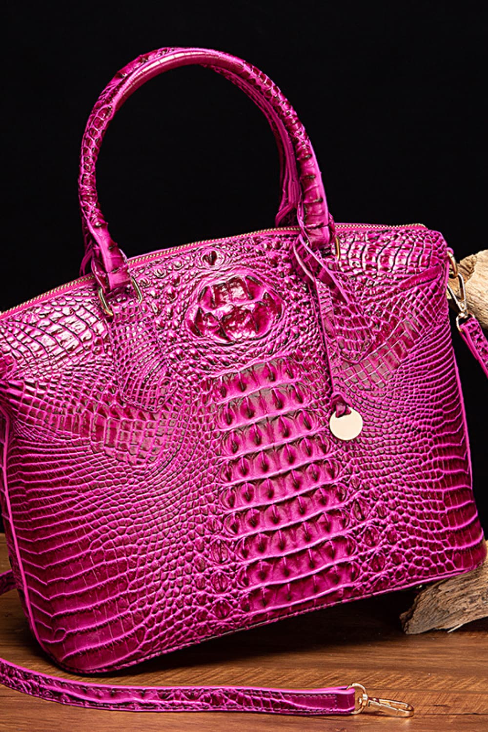 Croc-embossed vegan leather handbag in magenta pink with top handles and front emblem