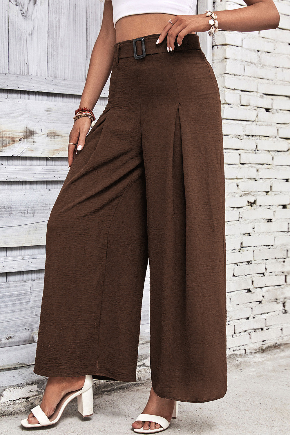 High-waisted wide-leg pants in dark brown with front pleat and structured waistband.