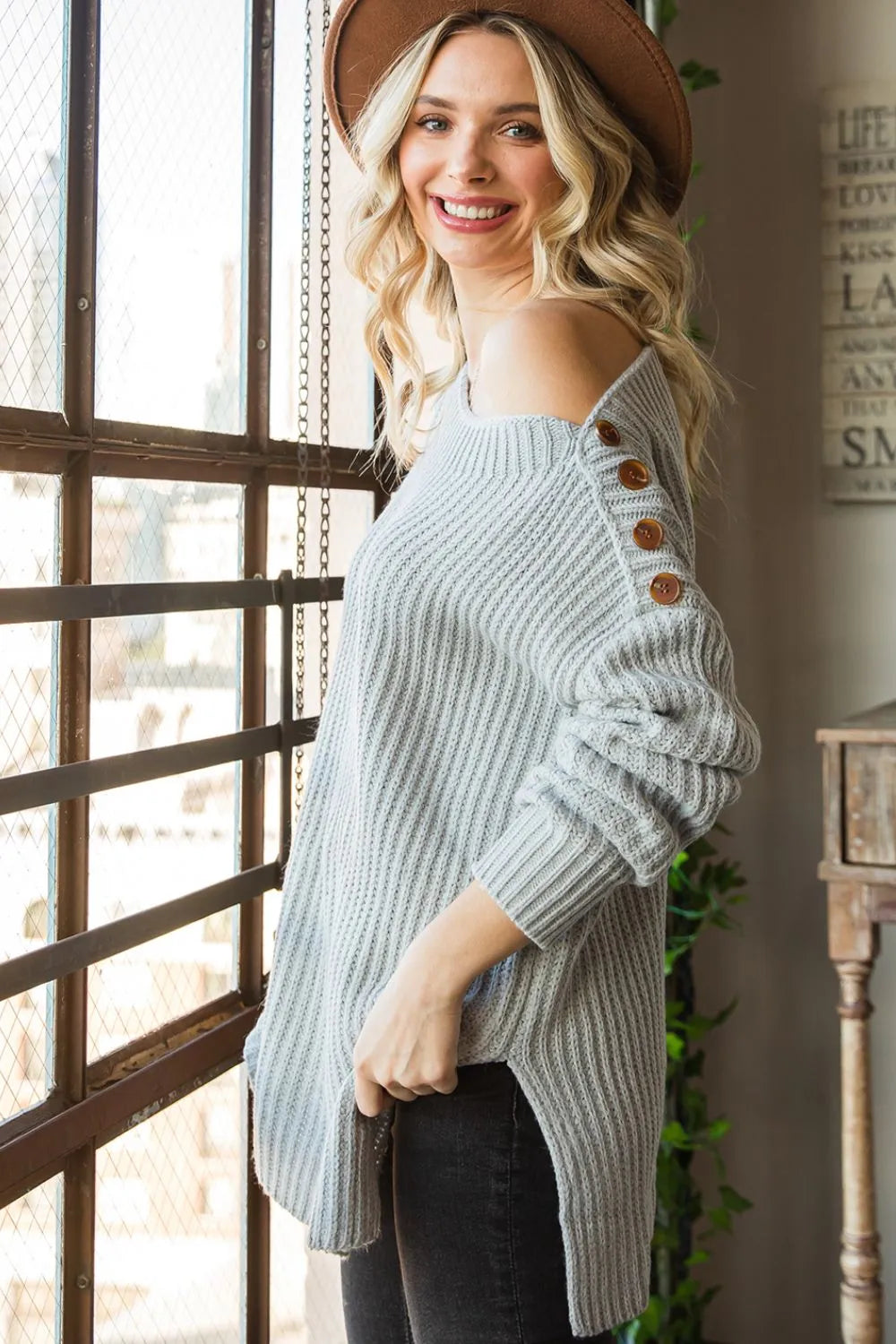 Light gray cold-shoulder knit sweater with boat neck, long sleeves, and chest buttons
